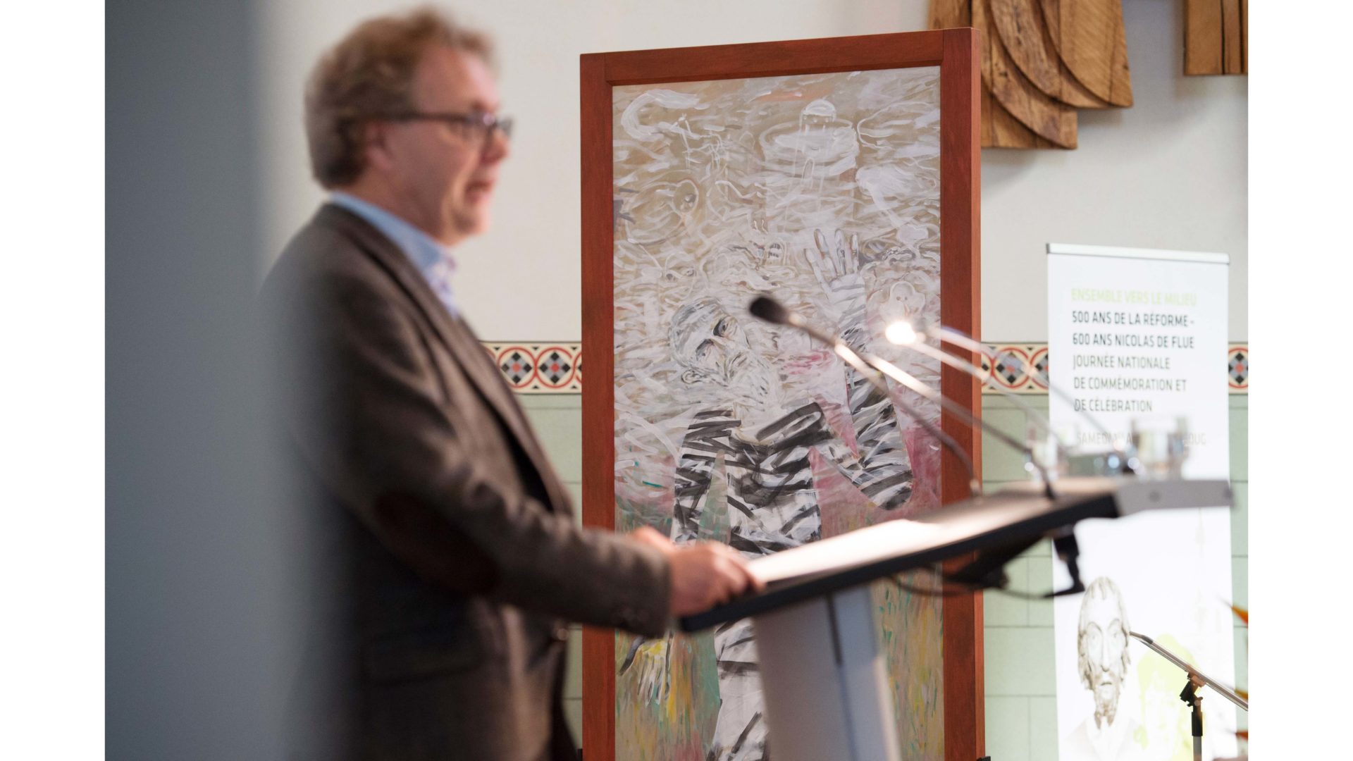 Der Historiker Josef Lang anlässlich seiner Rede vom 1. April 2017 in der Citykirche Zug. Im Hintergrund der tanzende Mystiker (2011, Bruder Klaus) von Benno K. Zehnder. (© SEK, Bern)