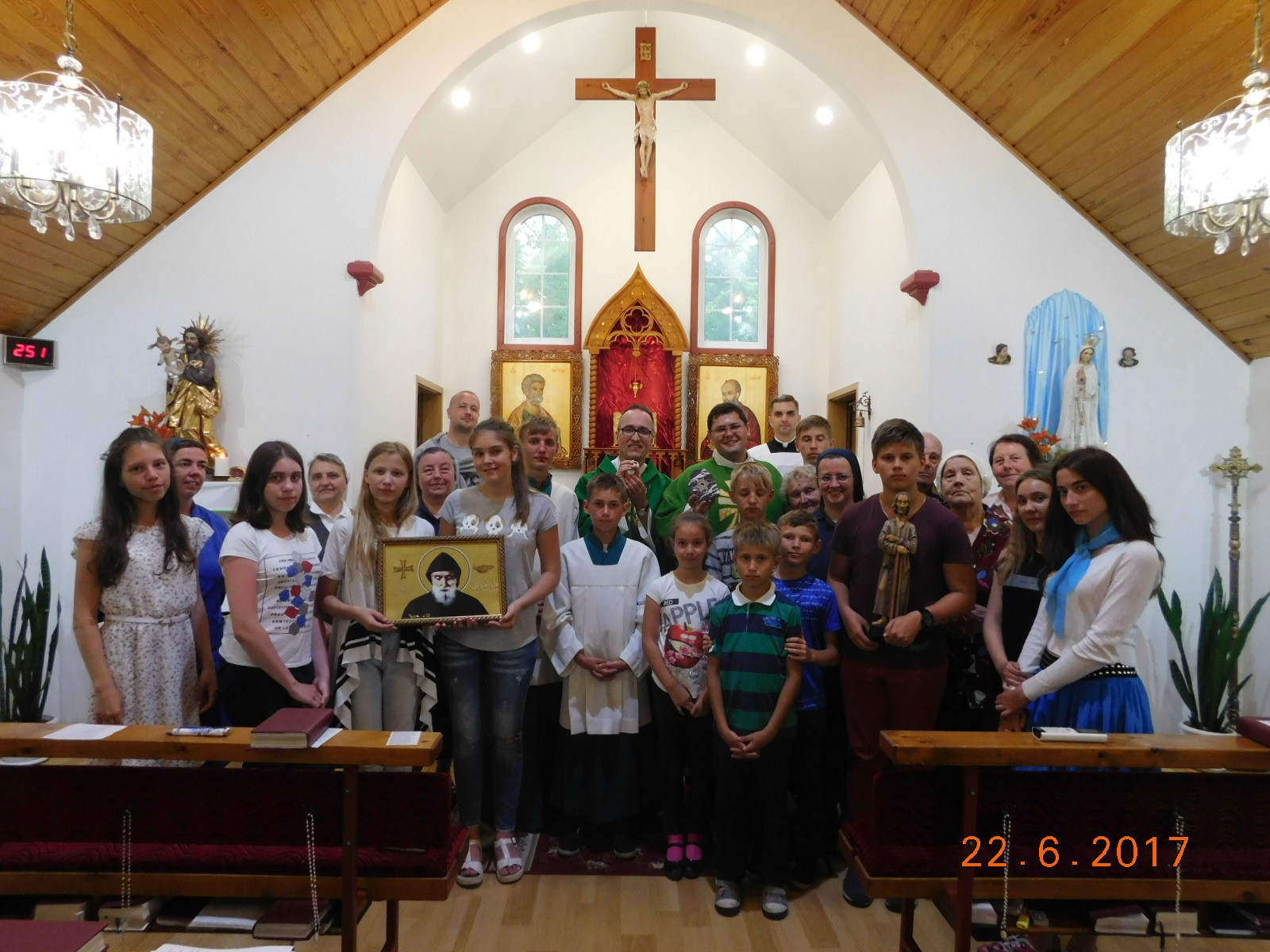 Gruppenbild in der Pfarrkirche von Kujbyschew mit der Statue von Bruder Klaus (rechts) und dem Bild des hl. Charbel Makhlouf (links).